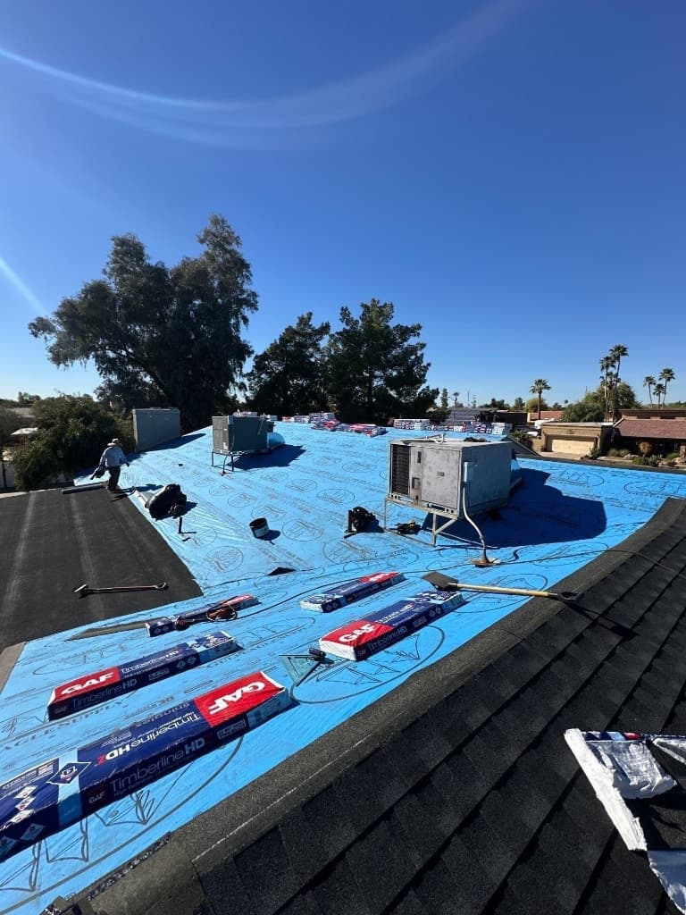 Asphalt shingle reroof in progress in Glendale, AZ with blue synthetic underlayment GAF Timberline HD and staged shingle bundles