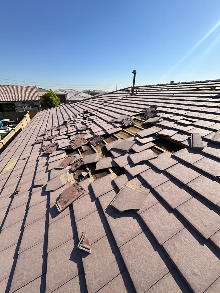Storm-damaged concrete tile roof in Litchfield Park, AZ with broken and displaced tiles before repair