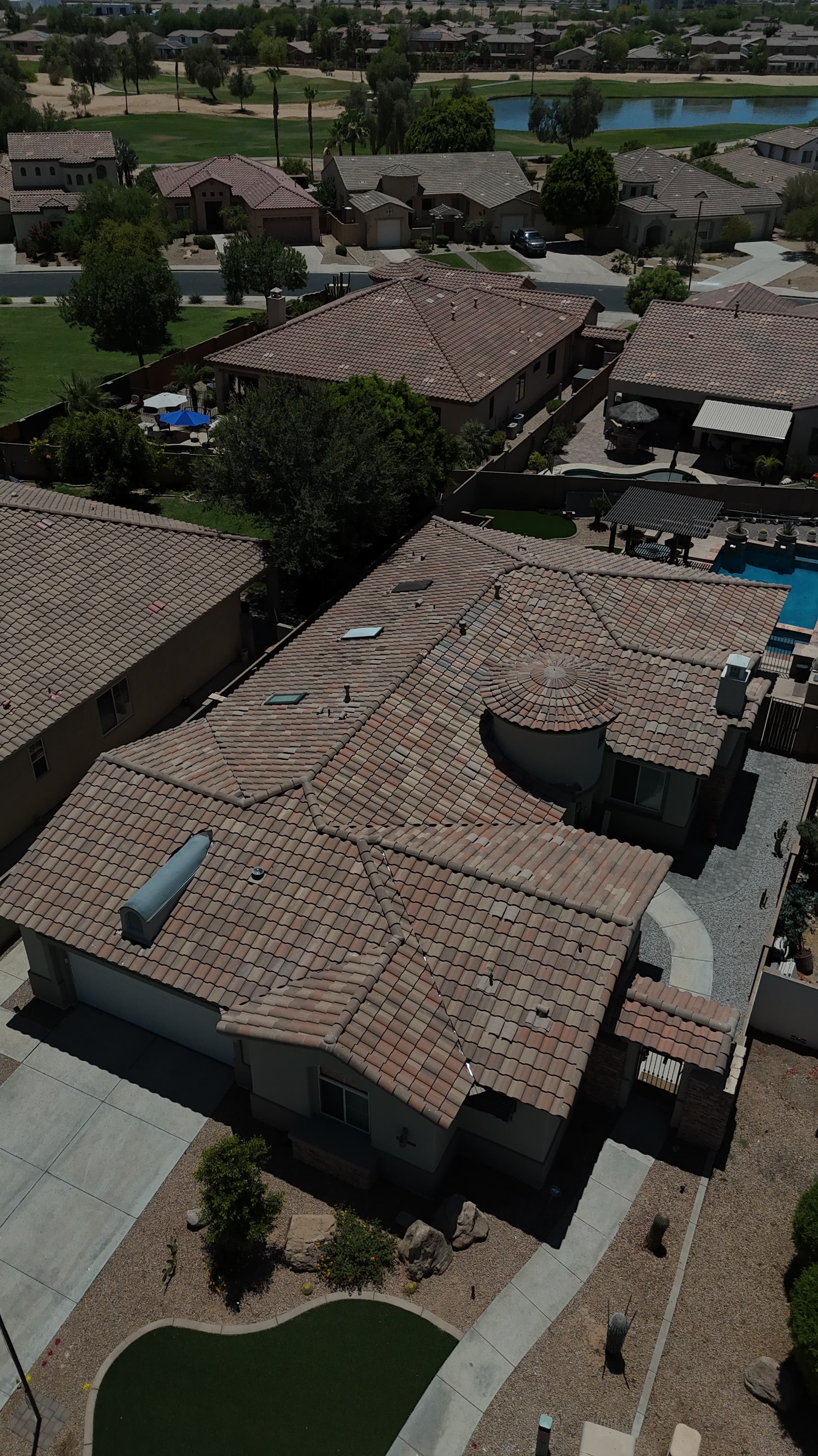 Aerial of a tile re-felt in Goodyear, AZ with fresh underlayment across the roof and tile bundles staged for relay