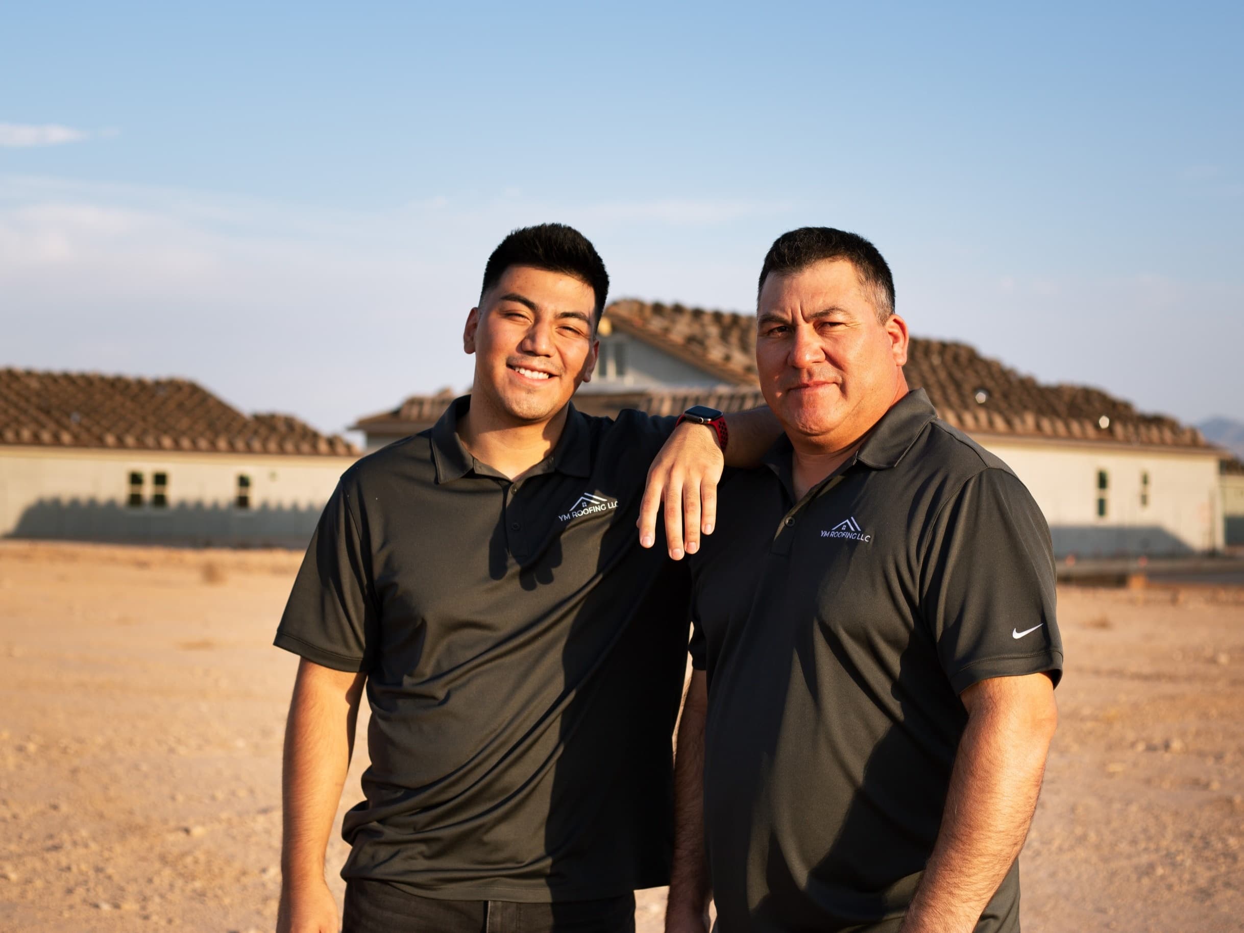 Anthony and Yuri of YM Roofing, a father-and-son crew, in front of an Arizona tile home